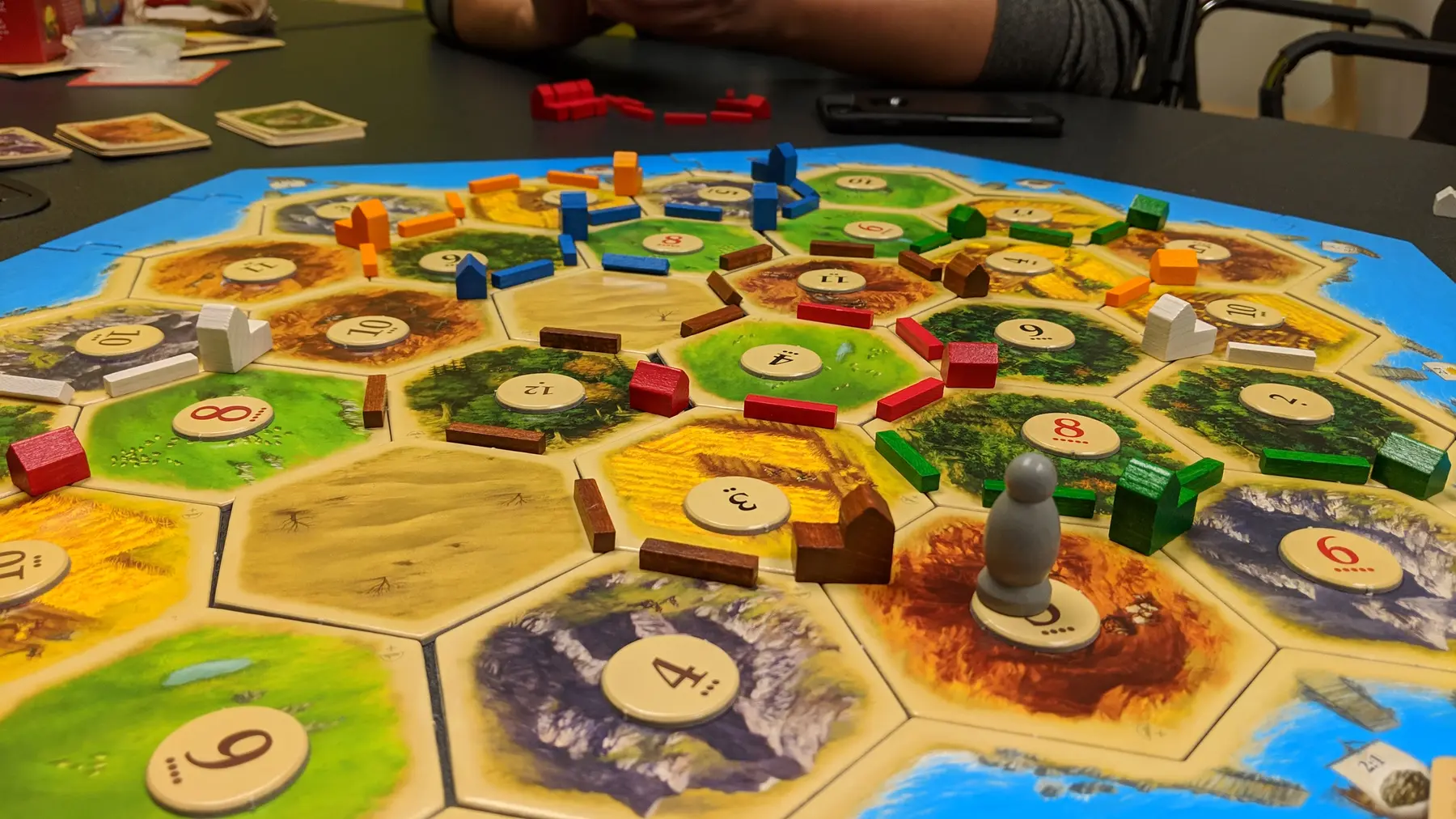 六角形の地形タイルと街道が並ぶカタンのゲーム盤